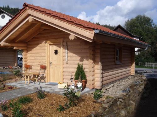 a log cabin with a dog in front of it at Chalet Hüttendorf 49 gradnord in Bayerisch Eisenstein