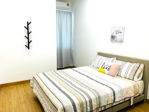 1 dormitorio con 1 cama con manta a rayas en A43 near Setia City Convention Centre & Bukit Raja en Shah Alam