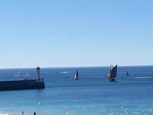 a group of sailboats in the water near a beach at Penty á Plogoff-Pointe du Raz in Plogoff
