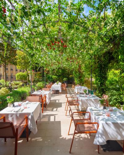 a restaurant with tables and chairs under trees at Shangri-La Paris in Paris