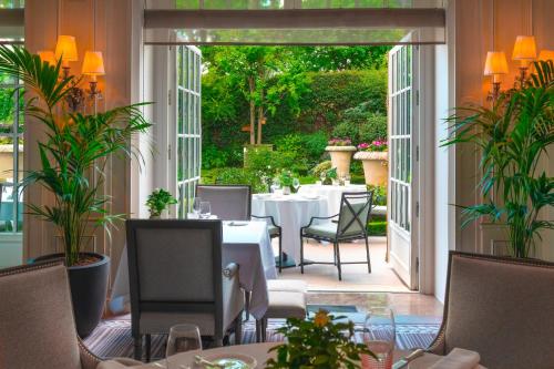 a dining room with tables and chairs and a patio at Shangri-La Paris in Paris