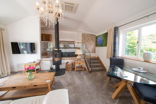 a living room with a dining table and a fireplace at Hawkshead Suites in Hawkshead