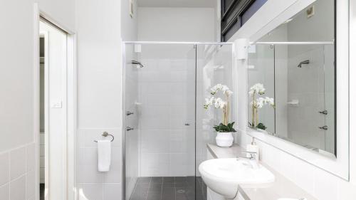 een witte badkamer met een toilet en een wastafel bij Sails on the Beachfront - Exclusive Seaside Home in Anna Bay