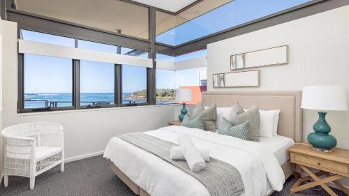 una camera con un grande letto e vista sull'oceano di Sails on the Beachfront - Exclusive Seaside Home ad Anna Bay