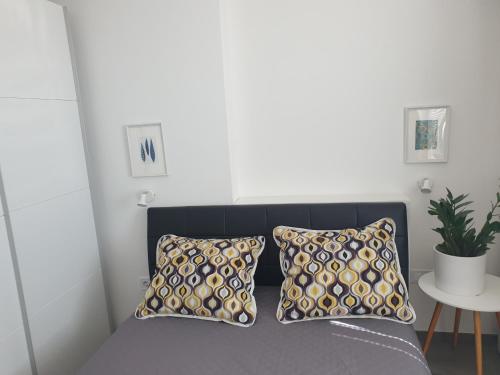 een slaapkamer met een bed met 2 kussens en een tafel bij Apartman Liliana in Rijeka
