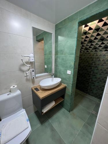 a bathroom with a sink and a toilet and a mirror at Готель-ресторан Два Леви in Slavske