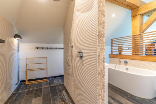 La salle de bains est pourvue d'une douche, d'une baignoire et d'un lavabo. dans l'établissement Buytenplaats Villa 187, à De Koog
