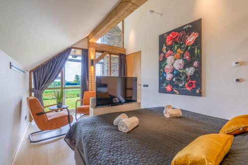 um quarto com uma cama grande e uma televisão em Buytenplaats Villa 187 em De Koog
