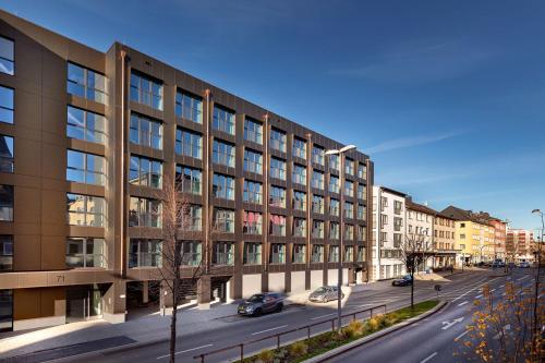 een groot gebouw in een straat met auto's aan de voorkant bij Green Stay in Essen