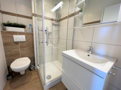 een badkamer met een douche, een toilet en een wastafel bij Ferienpark Sierksdorf App 782 - Strandlage in Sierksdorf