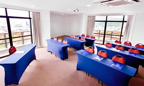 uma sala de aula com cadeiras e janelas azuis e vermelhas em Blue Tree Towers Joinville em Joinville