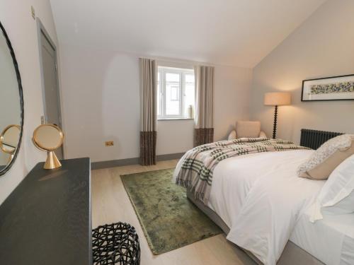a bedroom with a white bed and a window at Garden House in Amlwch