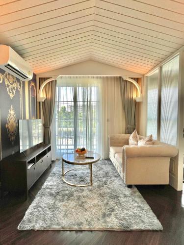 a living room with a couch and a table at Grand Florida Beachfront Resort Jomtien Pattaya in Na Jomtien