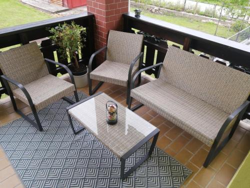a patio with three chairs and a table with a table at Apartment Wigo in Feldkirchen in Kärnten