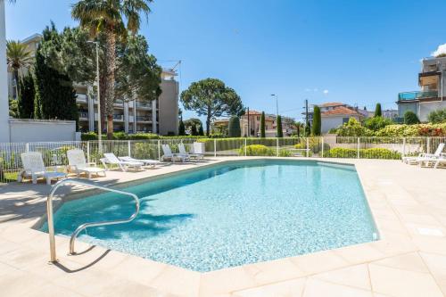 une grande piscine avec des chaises dans l'établissement 3-Room Luxury Apartment with Pool and Sea View Steps from the Beach, à Cannes