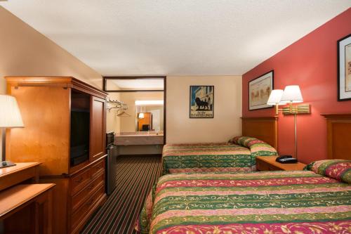 a hotel room with two beds and a flat screen tv at Knights Inn Aiken in Aiken