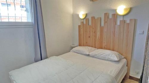 サント・マキシムにあるCoralinesのベッドルーム1室(木製ヘッドボード付きのベッド1台付)