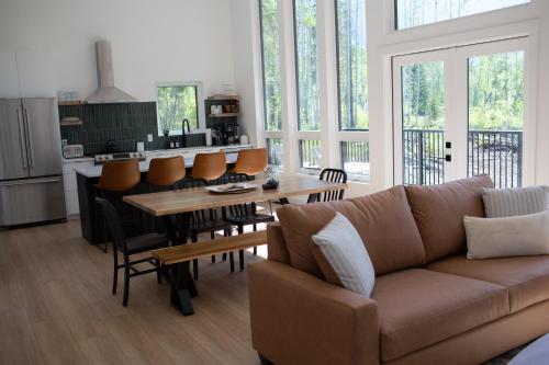 a living room with a couch and a table with chairs at Luxury Private Cabin In The Rockies in Golden