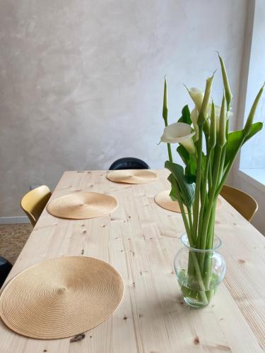 a wooden table with a vase of flowers on it at T-Rooms in Bassano del Grappa