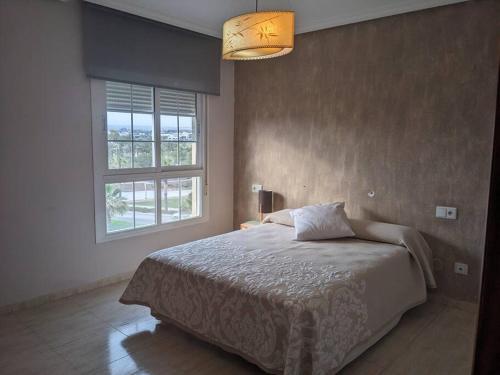a bedroom with a large bed and a window at ÁticoToyoAlmeria in Retamar