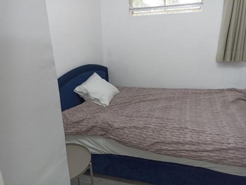 um quarto com uma cama com uma almofada e uma janela em הבית של יעל em Tel Aviv