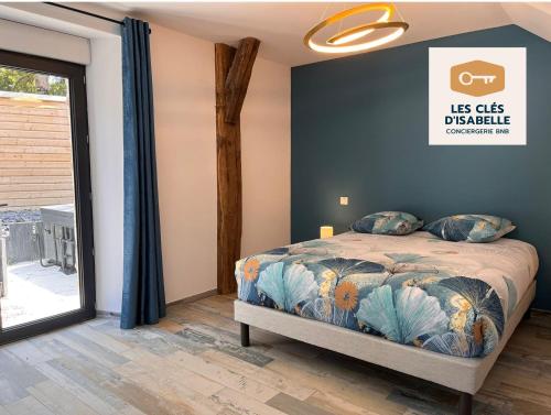 a bedroom with a bed and a large window at Le mas contemporain de Dun in Dun-le-Palestel