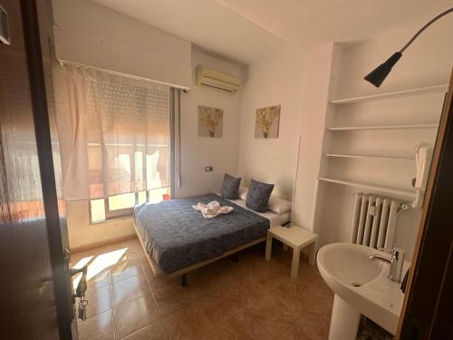 Dormitorio pequeño con cama y lavamanos en Hostal Arrate en Madrid