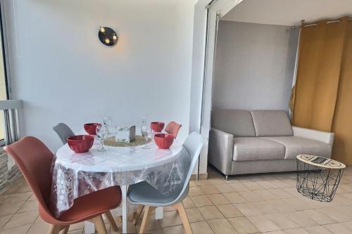 mesa de comedor con sillas y sofá en Coquet studio vue mer pour 4 personnes au Port de Valras-Plage, en Valras-Plage