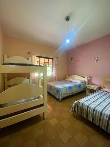 a bedroom with two beds and a window at chácara solar das águas in Socorro