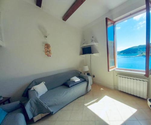 a living room with a couch and a large window at Vittoria 19 in Portovenere