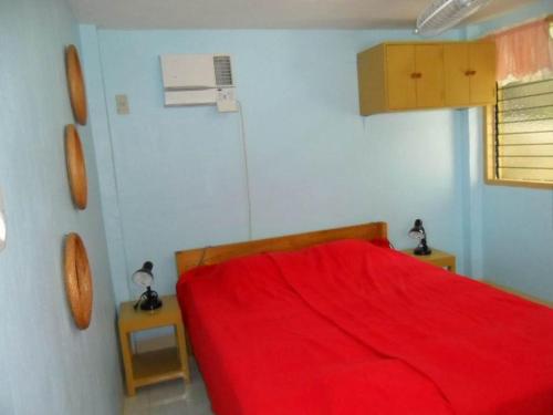 um quarto com uma cama vermelha com duas mesas de cabeceira em Karlsson's Guesthouse em Larena