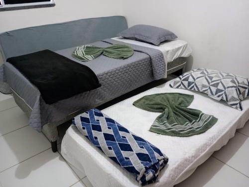 twee bedden met handdoeken in een kamer bij Apartamento Beira Rio no Condomínio Brisas do Lago in Paulo Afonso