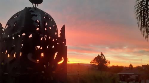 um pôr-do-sol com um cacto em primeiro plano em Estância Villa Ventura em Socorro