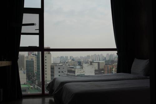 Ένα ή περισσότερα κρεβάτια σε δωμάτιο στο Myeongdong Merlin Hotel