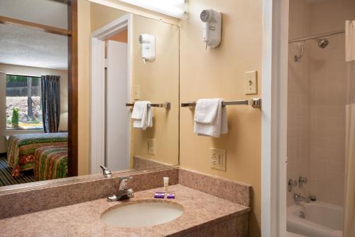 La salle de bains est pourvue d'un lavabo et d'un miroir. dans l'établissement Knights Inn Aiken, à Aiken