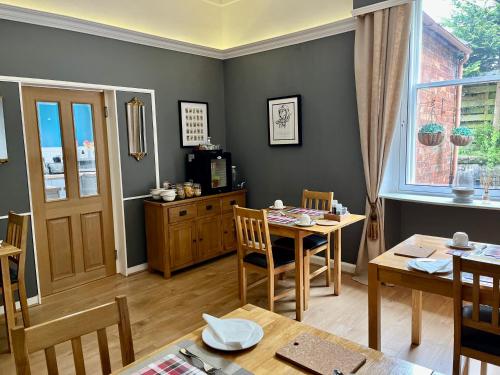 a dining room with a table and chairs and a window at Glenaldor House B&B in Dumfries