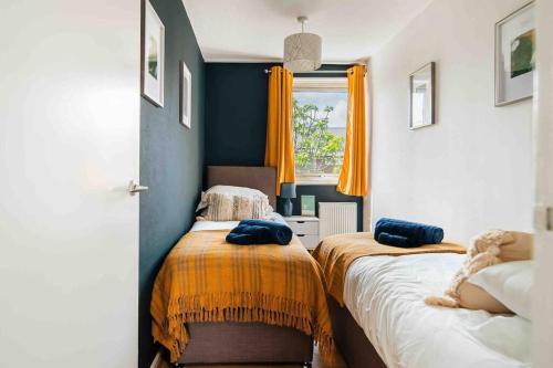 倫敦的住宿－Contractor base with Hot Tub and Pool table，一间卧室设有两张带橙色和蓝色墙壁的床。