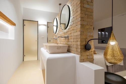 a bathroom with a sink and a brick wall at Anna Platanou Suites in Agia Irini Paros