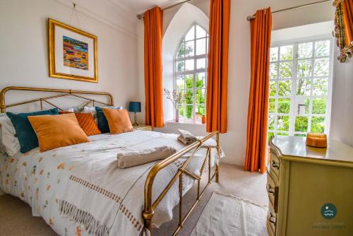 a bedroom with a bed with orange curtains and a window at The Old Chapel - Exclusive Retreat in Weymouth