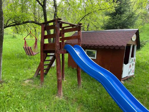 a playground with a slide and a house at Casa Titiana Suncuius in Şuncuiuş