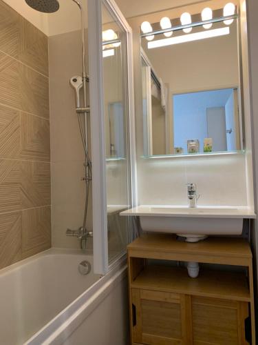 a bathroom with a sink and a tub and a mirror at Ambassadeur Hotel - Cherbourg Port de Plaisance in Cherbourg en Cotentin