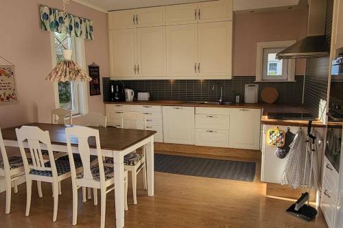 マリエスタードにあるCentralt i Mariestadの白いキャビネット、テーブルと椅子付きのキッチンが備わります。