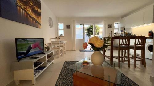 een woonkamer met televisie en een keuken bij Casa Cristal in Lagos