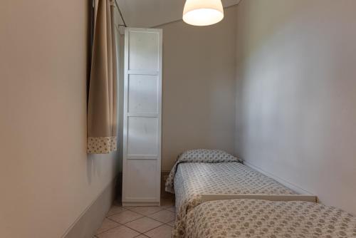 a small room with two beds and a cabinet at Agriturismo Nobile in Montepulciano