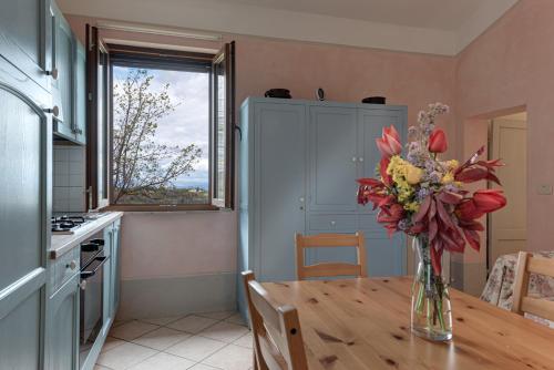 a kitchen with a table with a vase of flowers on it at Agriturismo Nobile in Montepulciano