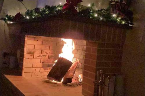 Una chimenea de ladrillo con fuego. en Gerania Villa en Písia