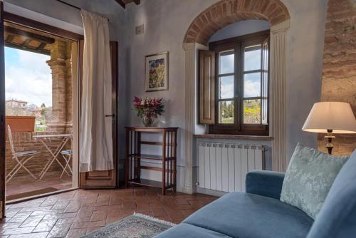 a living room with a blue couch and a window at Agriturismo Nobile in Montepulciano
