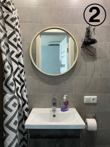 een badkamer met een wastafel en een spiegel bij Studio Aparment in Charkov