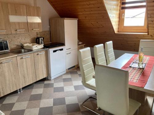 uma cozinha com uma mesa e cadeiras numa cozinha em GANCZ APARTMAN em Sárvár