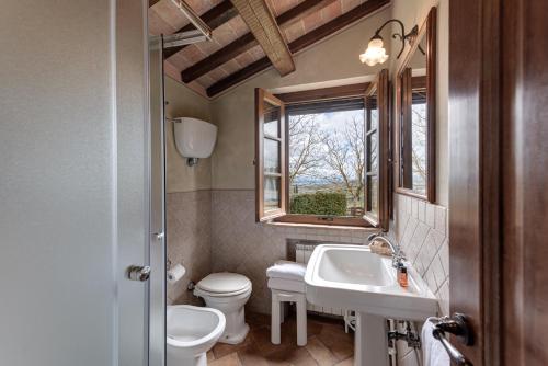 a bathroom with a sink and a toilet and a window at Agriturismo Nobile in Montepulciano